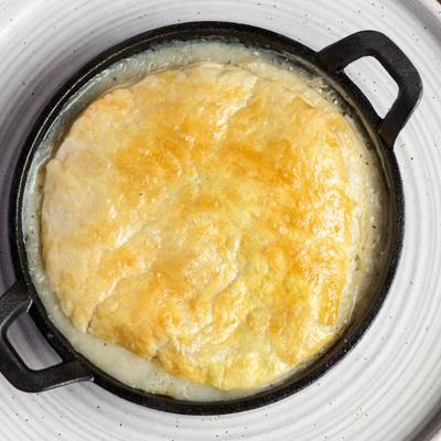Skillet chicken pot pie topped with a flaky pastry crust.