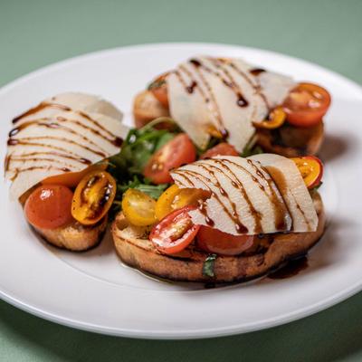 Bruschetta with cherry tomatoes, arugula and Parmesan.