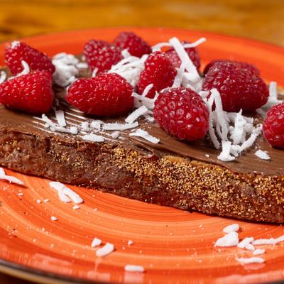 Chocolate toast topped with fresh raspberries & coconut.
