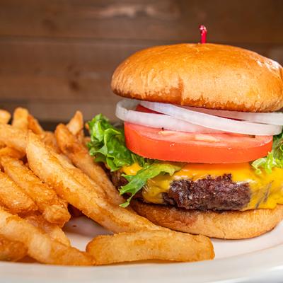 Classic cheeseburger with fries on the side, close-up.