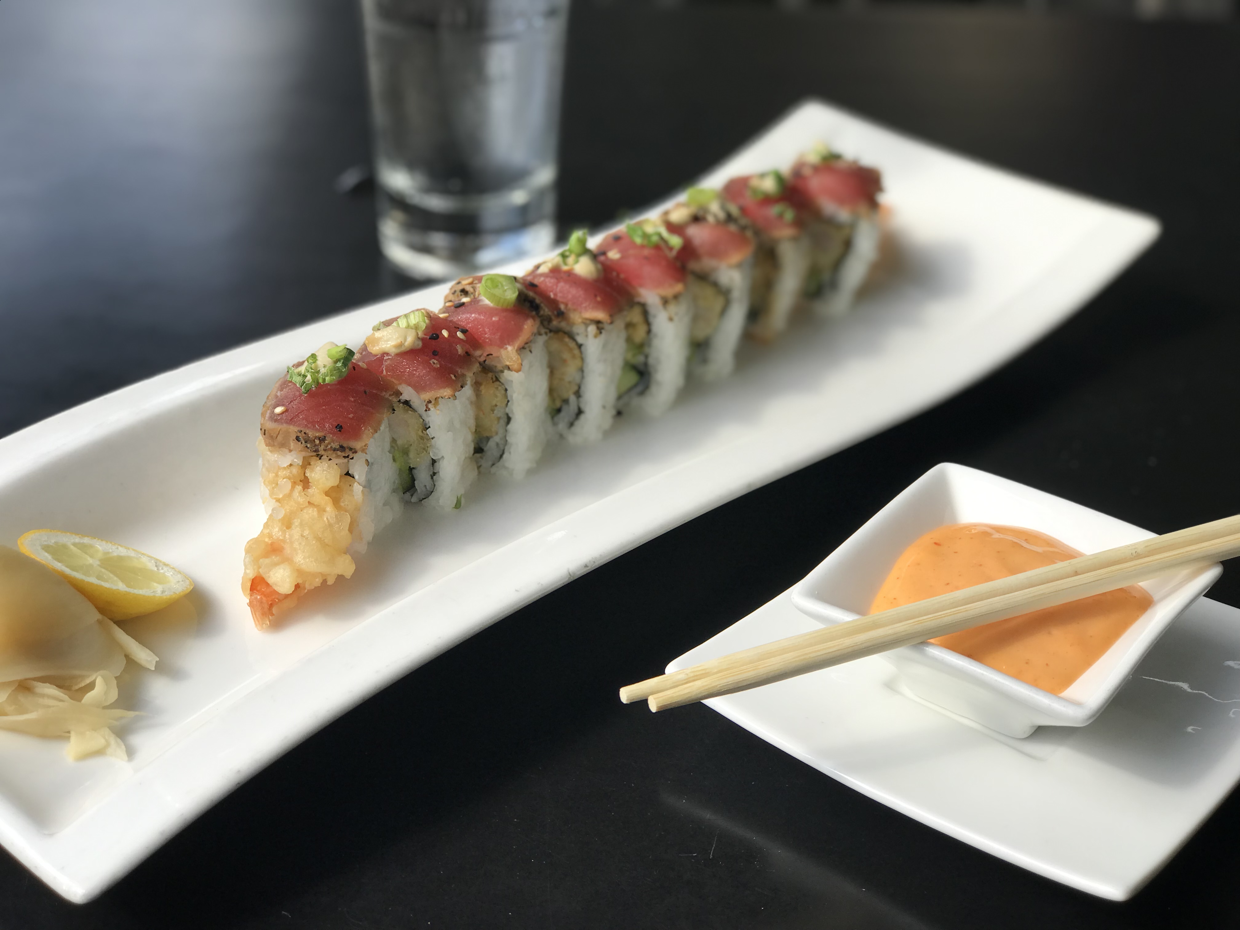 A picture of our Angry Dragon sushi roll sliced and featured on a plate