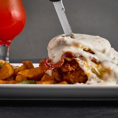 Fried chicken breast, fried egg, bacon, and cheddar, topped with sausage gravy.