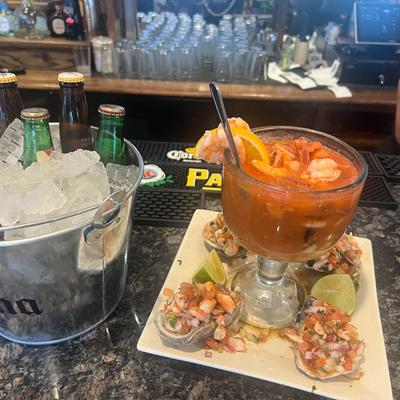 Shrimp cocktail served with shrimp-topped oysters and a bucket of beer with ice.
