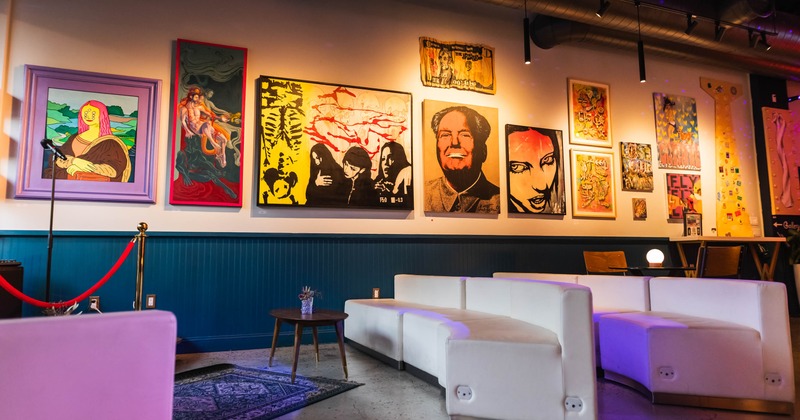 Lounge area featuring white sofas and pop art style paintings on a wall