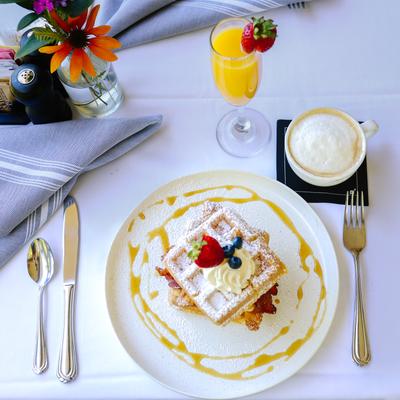 Waffles topped with whipped cream and berries served with coffee and juice.