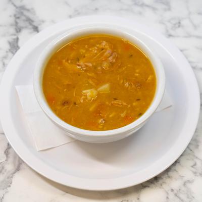 Ssoup served in a white bowl on a matching plate.