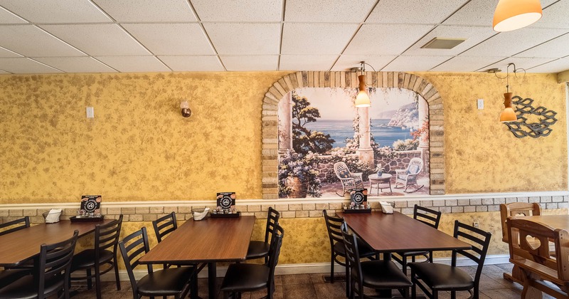 Interior, tables and chairs near decorated wall