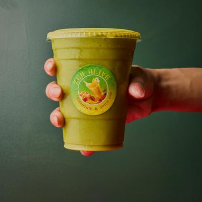 Hand holding a plastic cup with a smoothie.