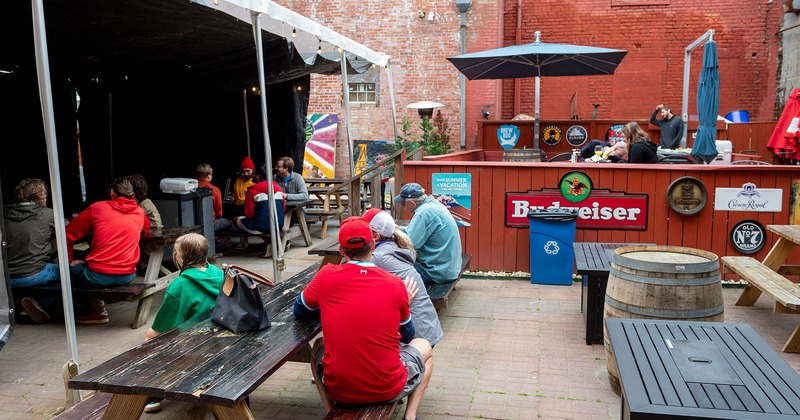 Exterior, patio seating with guests sitting at tables and the bar