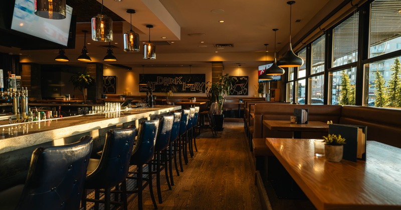 Interior, bar and seating area, marble top bar with stools, seating booths on the right