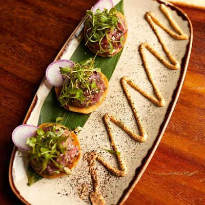 Tuna tostadas, with cucumber, cilantro, red onion, peppers, sesame seeds, and chipotle aioli.