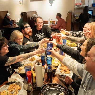 Group of people toasting each other at a restaurant.