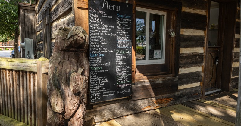 Ice cream menu and a wood carved bear statue
