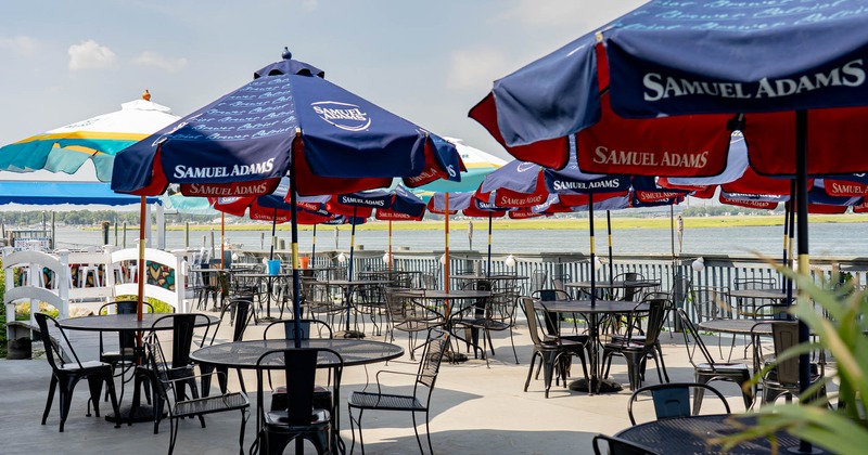 Outdoor patio with tables and umbrellas by the water