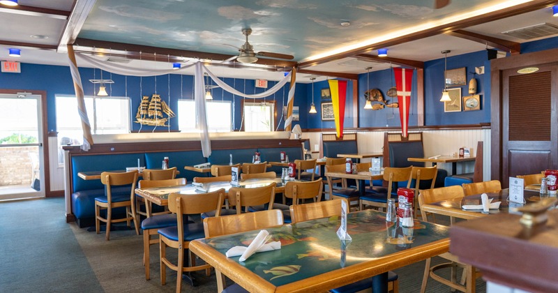 Interior, dining area, tables and chairs ready for guests, banquette bench with tables
