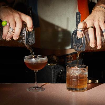 Bartender pouring two cocktails at once.