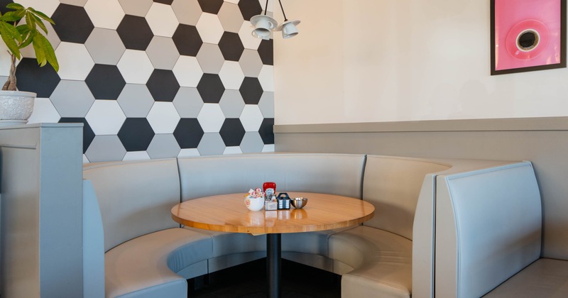 A restaurant booth with a semi-circular banquette, wooden table
