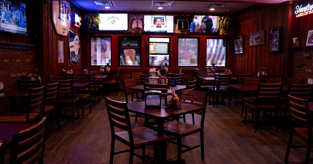 Covered seating area with wooden chairs, tables and walls
