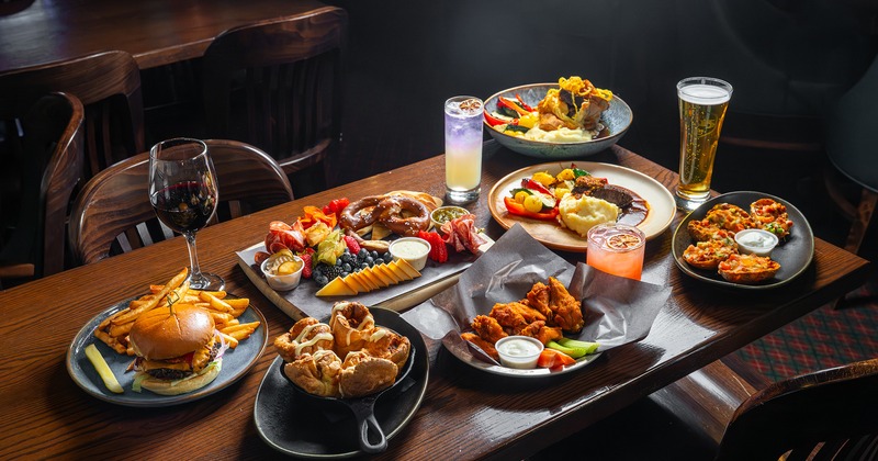 A variety of pub foods and drinks on a wooden table