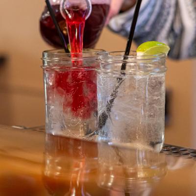 Bartender preparing cocktails in mason jars.