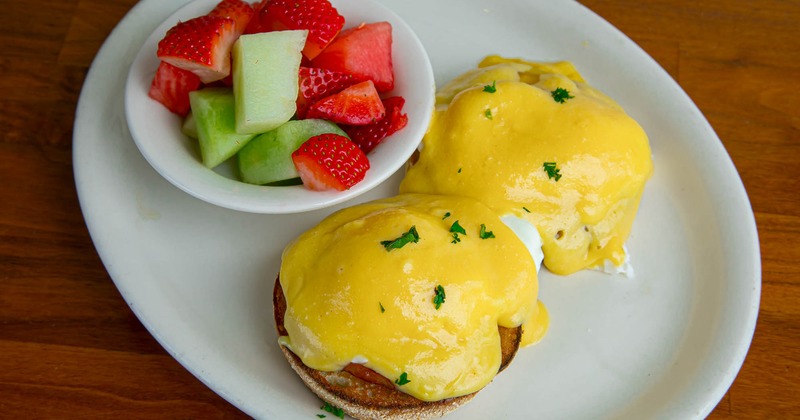 Eggs benedict with a fruit salad