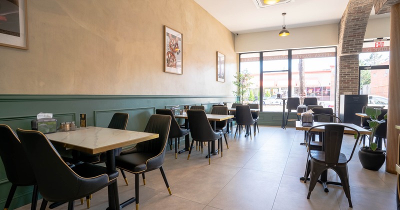 Spacious cafe interior with modern black chairs and wooden tables