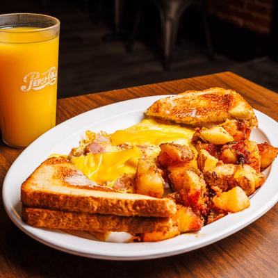 Ham and cheese omelet with toast, home fries, and a glass of orange juice.
