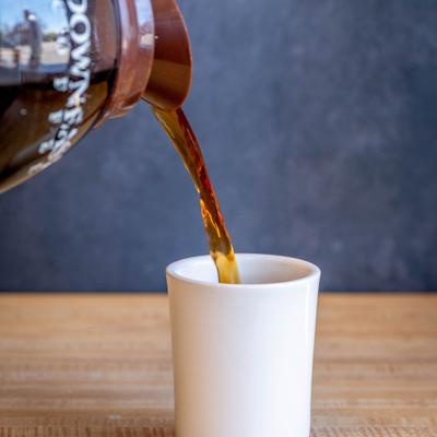 Coffee being poured into a white cup.