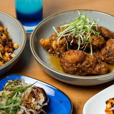 Karaage wings served alongside other dishes and a cocktail.