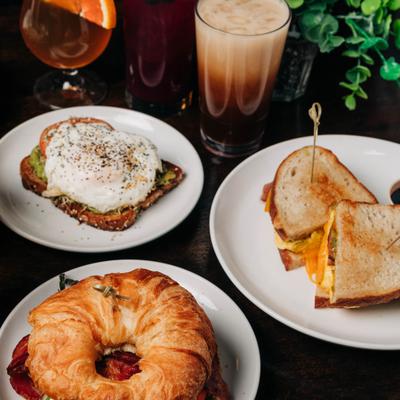 Breakfast sandwiches and beverages served on a restaurant table.