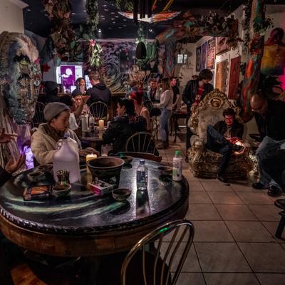 The bar's large interior area, decorated for a special event, lots of guests.