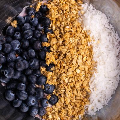 Acai bowl topped with fresh blueberries, granola, and shredded coconut.