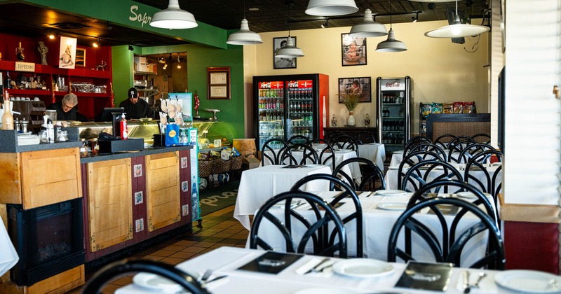 Interior of a restaurant with tables set for dining and a counter area