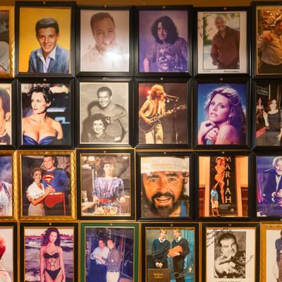 Wall decorated with a grid of framed images of various celebrities.
