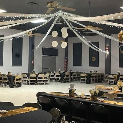 Interior, tables and seating in a banquet hall with string lights on the ceiling