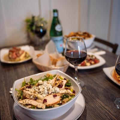 Interior, Assorted dishes served  on a table with glasses of red wine.