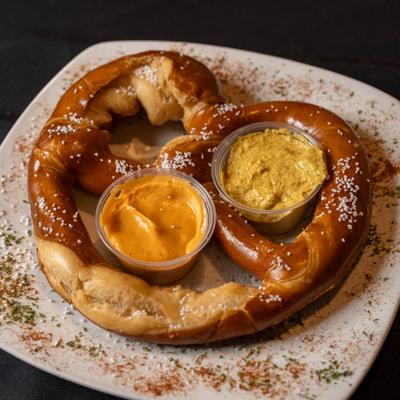 Pub Pretzel served with white cheese sauce and stone ground creole brown mustard.