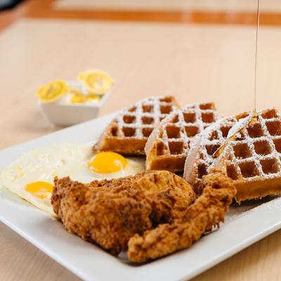 Fried chicken and waffles served with sunny-side eggs.