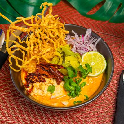 Yellow curry soup with chicken, crispy egg noodles, fresh lime, shallot and pickled cabbage.