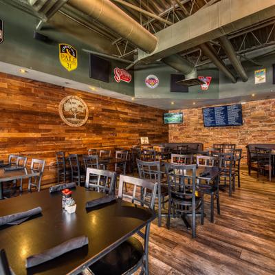 Restaurant interior featuring wood-paneled walls, tables, and beer signs.