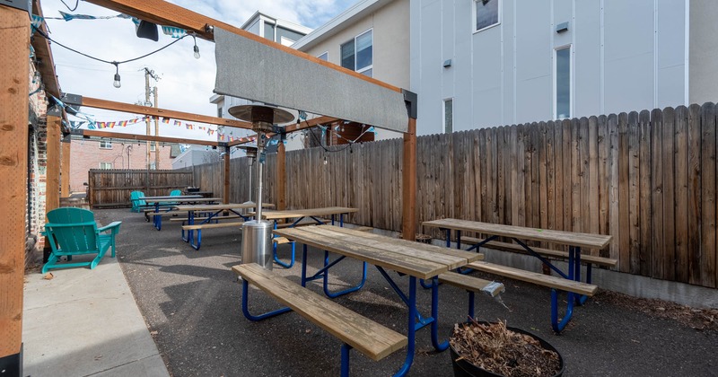 Exterior, wooden top tables and benches in a backyard, space heaters