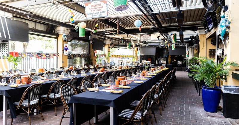 Outdoor dining area with long tables, festive decorations, and brunch signs