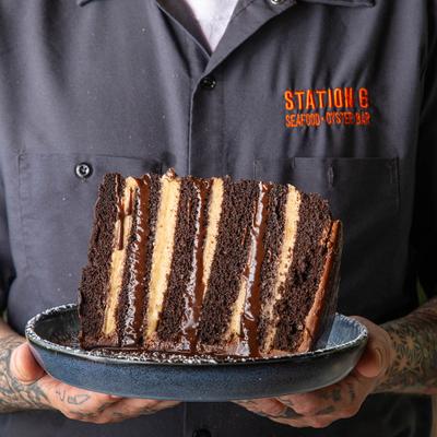 Employee with a chocolate cake piece on a plate.