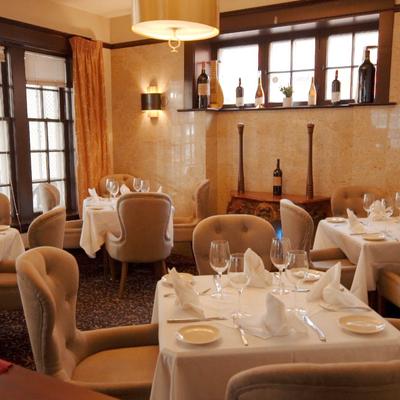 Restaurant interior featuring elegantly set tables and chairs prepared for dining.