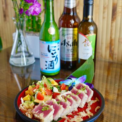 Seared ahi tuna with vegetables and drinks.