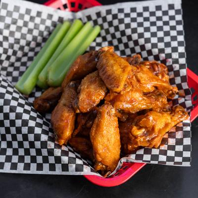 Buffalo wings served with celery sticks.
