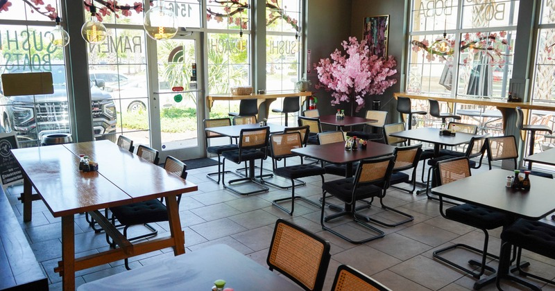 Interior, dining area featuring wooden tables, black chairs, and large windows
