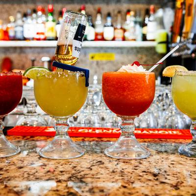 Assorted colorful cocktails on a bar counter.