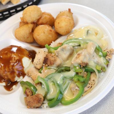 Chicken tips over rice, with side of hush puppies and mashed potato
