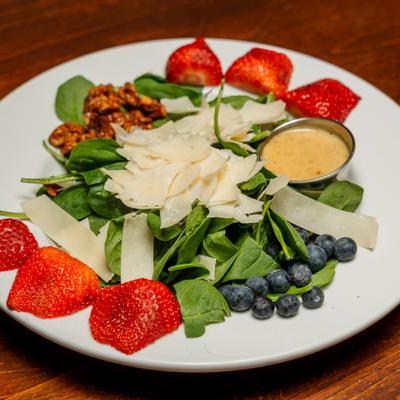 Spinacchio salad with candied walnuts, strawberries, blueberries and parmesan.